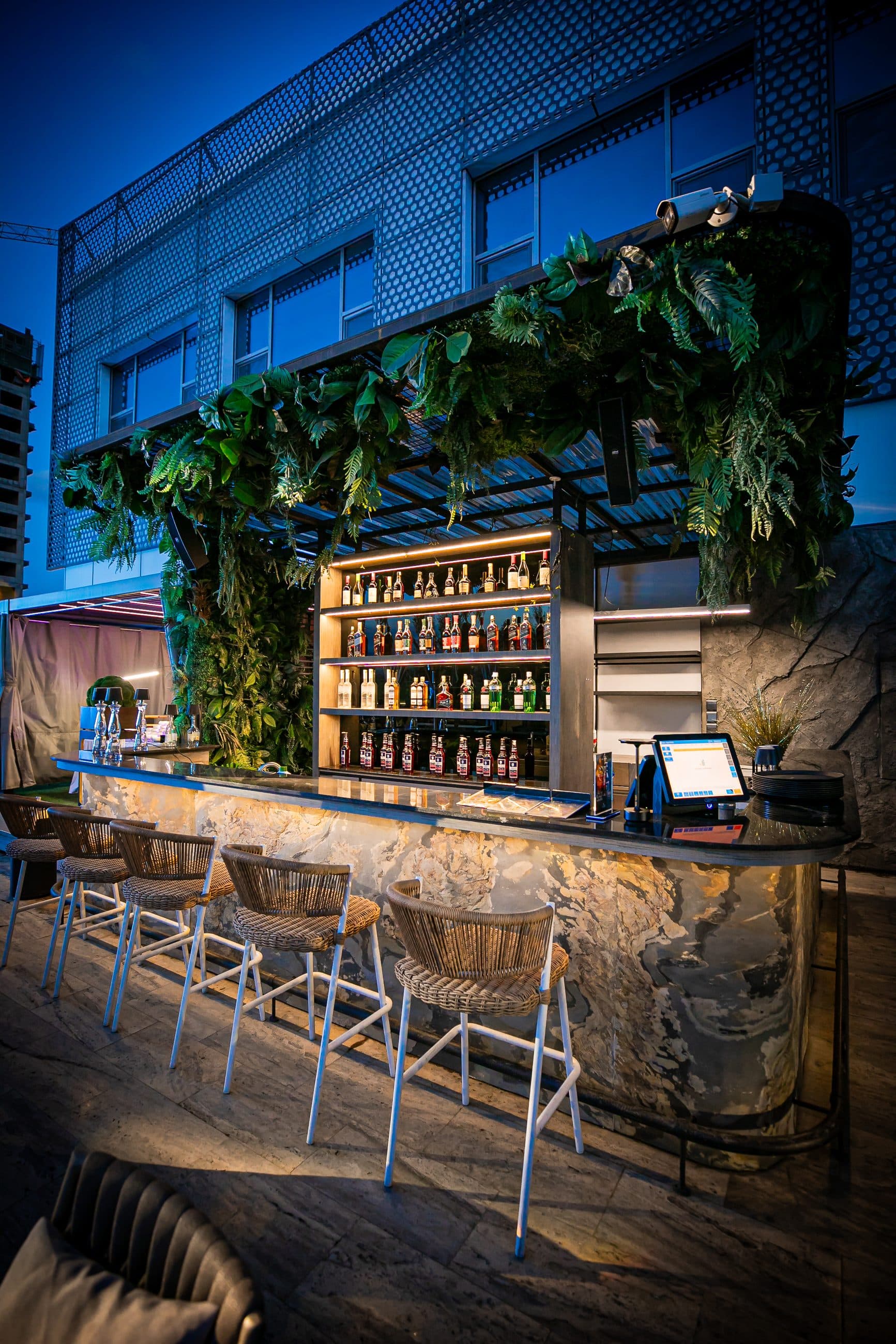 The terrace bar with its greenery canopy and marble counter